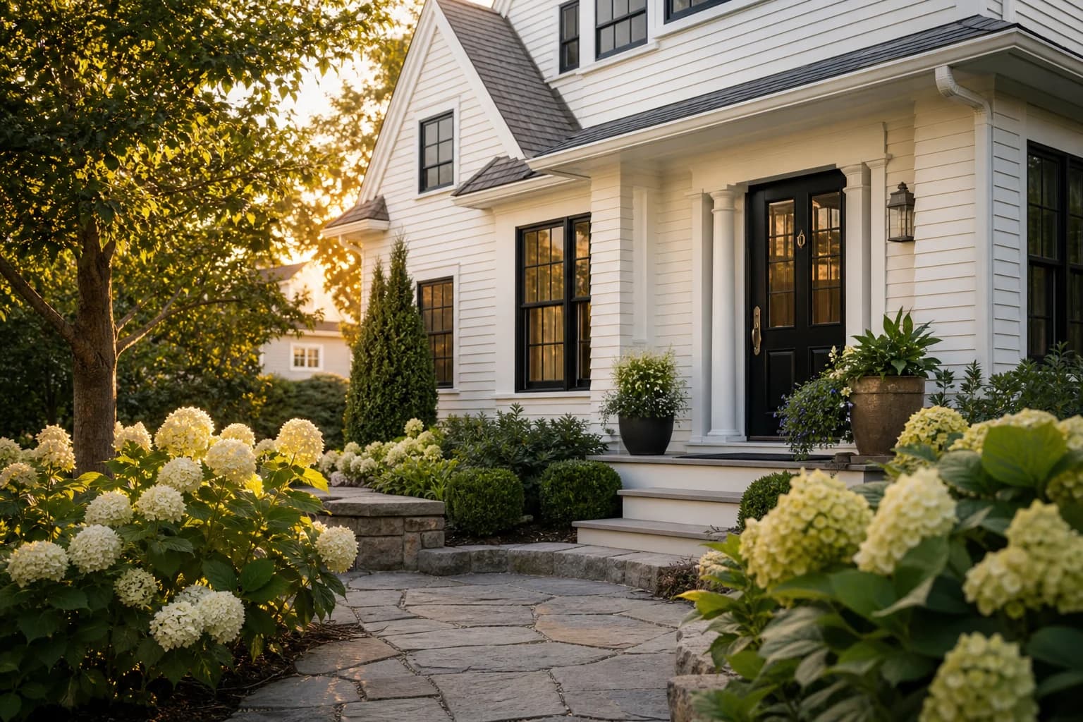 Welcoming New England home surrounded by hydrangeas at golden hour